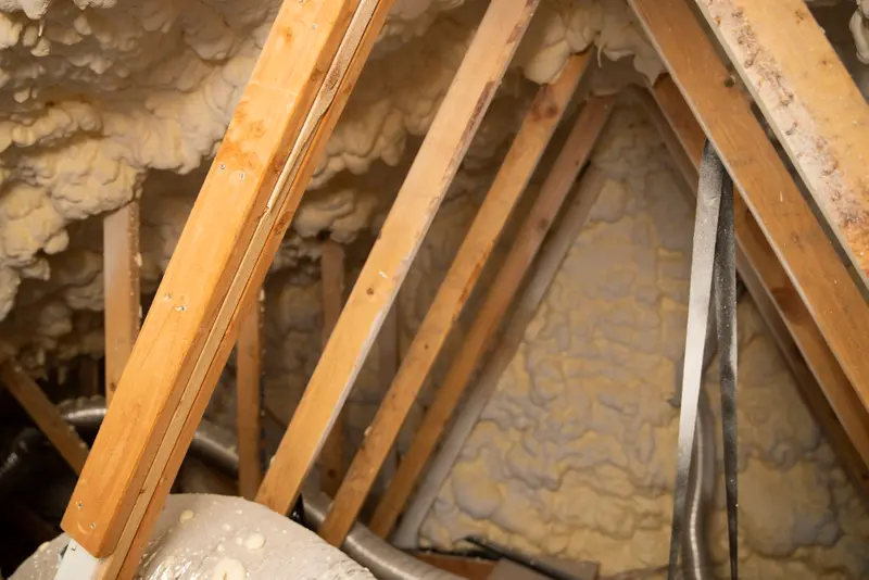 Wooden boards forming peaks and surrounded by insulation. One board is visibly cracked and has an extra board attached to each side.